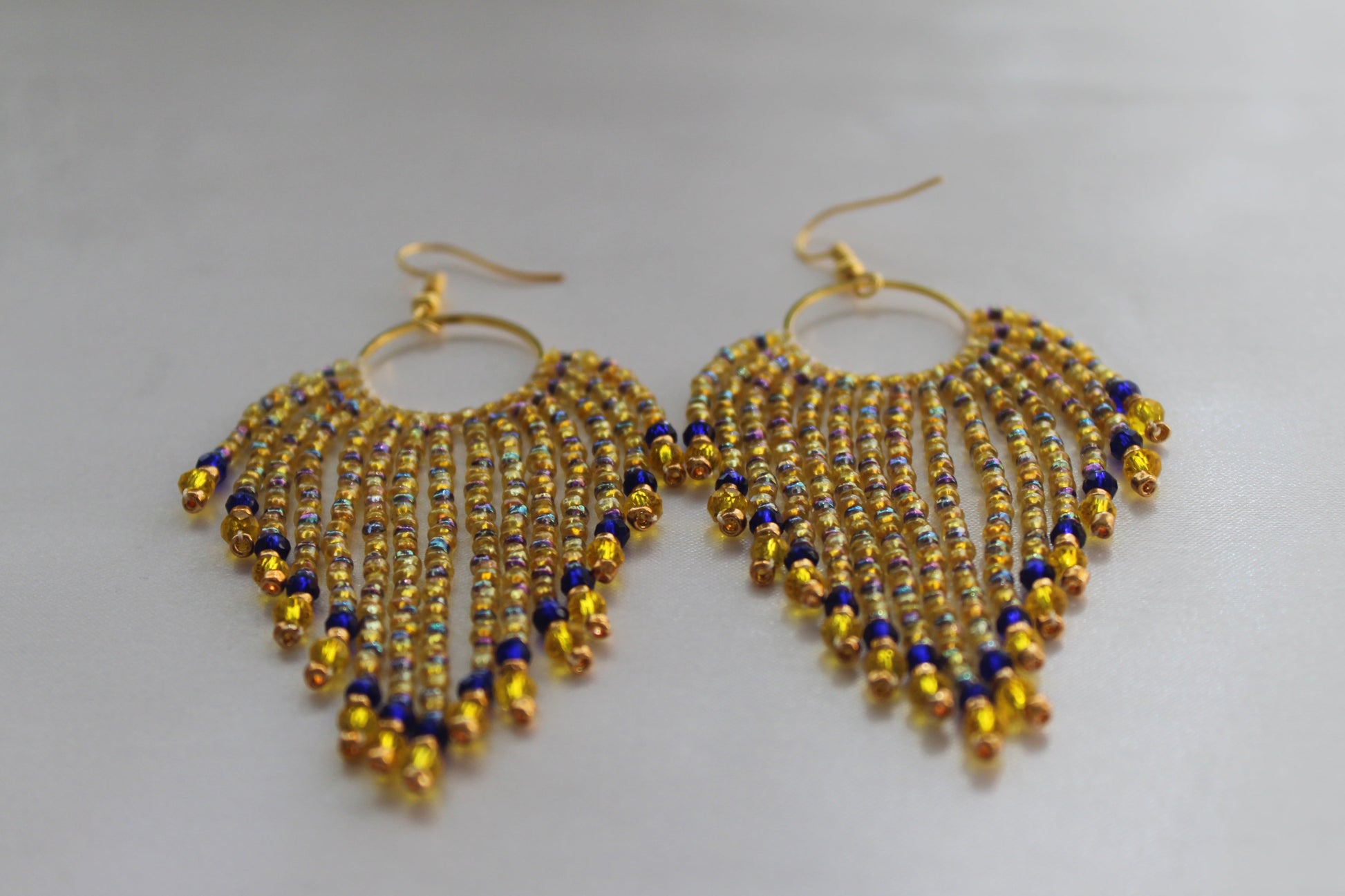 Handmade gold, royal blue, and amber beaded fringe earrings with cascading tassel strands suspended from gold-tone hoops, lightweight boho statement dangle jewellery.